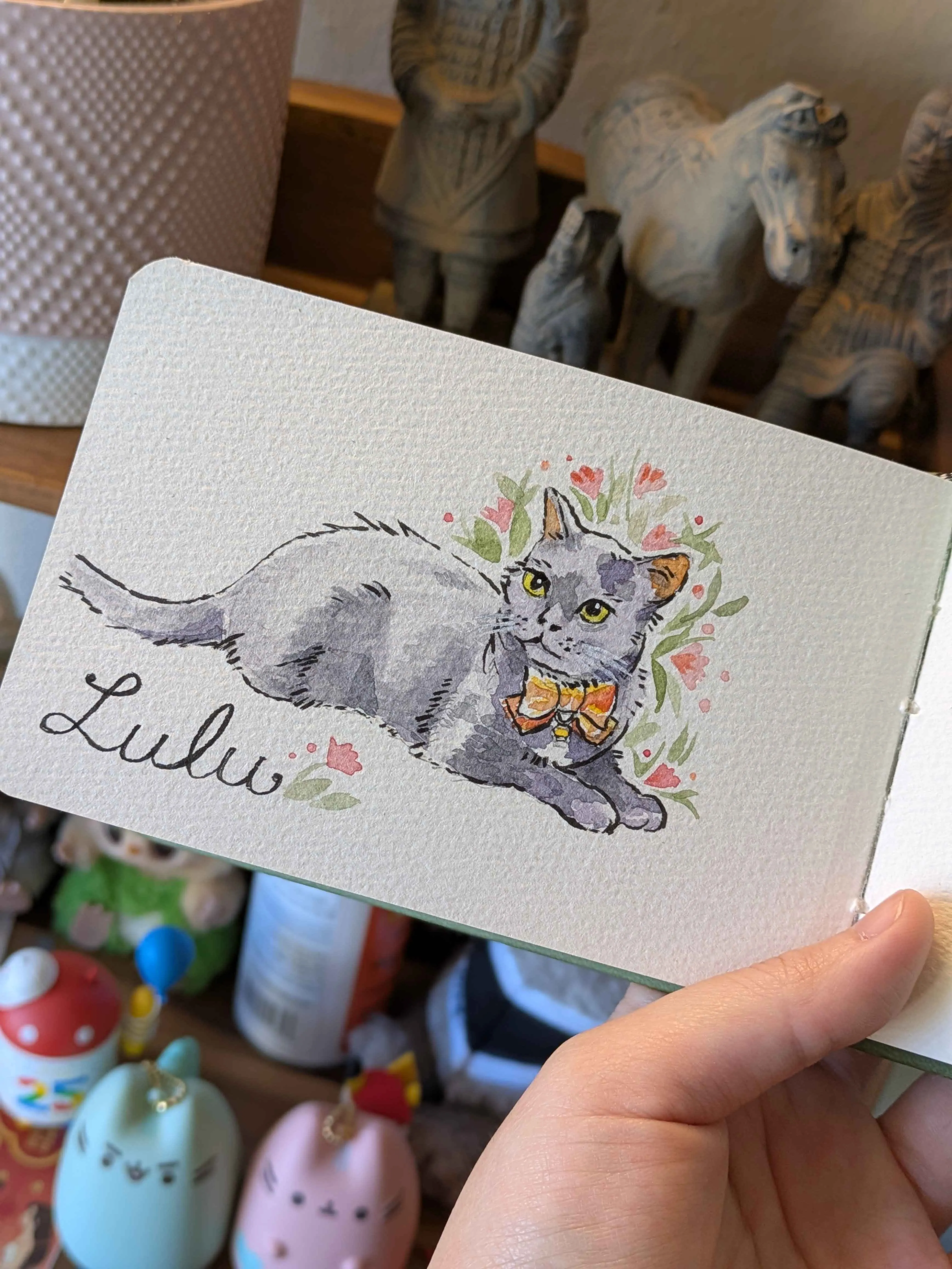 Watercolor sketch of Lulu the cat in a sketchbook
